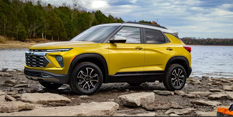  A yellow 2025 Chevrolet Trailblazer parked and the rocky shores of a lake.
