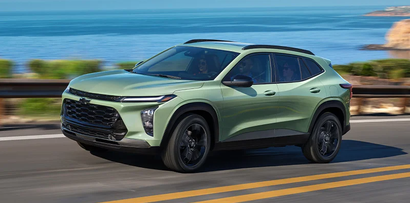 A green 2025 Chevrolet Trax driving down the road.