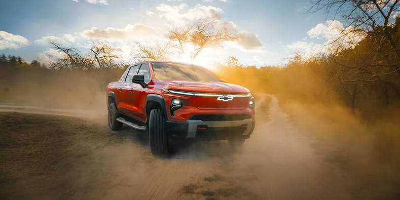A photo of a 2026 Chevrolet Silverado EV driving down a dirt road.